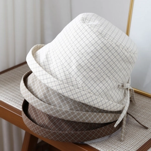 Women's plaid bucket hat with sun protection brim and decorative bow tie detail