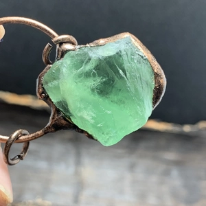 Primer plano de piedra de fluorita verde en bruto con engaste de bronce estilo vintage