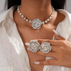Gros plan d'un mannequin portant un ensemble collier et bague rose argentée avec strass