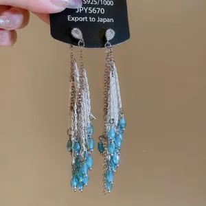 Détail de boucles d'oreilles à pampilles avec zircons en forme de goutte de style vintage