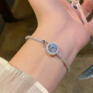 Detailed view of silver flower bracelet with zircon and pearls worn on a wrist