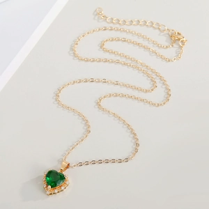 Detail of emerald green heart pendant with crystal border on gold adjustable chain