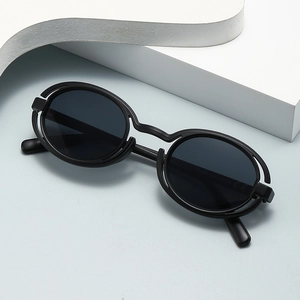 Punk style small round sunglasses in matte black with UV400 protection on white blocks