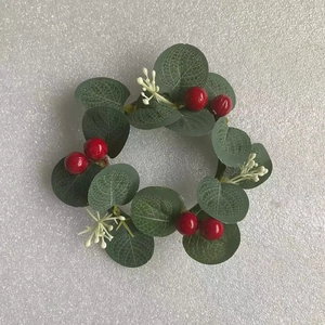 Detailed view of mini Christmas wreath with green eucalyptus leaves and red berries