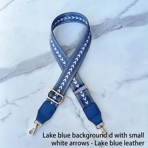 Detail of adjustable blue jacquard strap with white arrow pattern and gold hooks