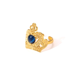 Detail of a gold crown ring with a blue gemstone center and adjustable open band