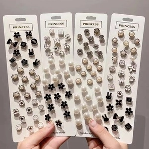 Detailed set of multi-style stud earrings with pearls and floral motifs on white cards