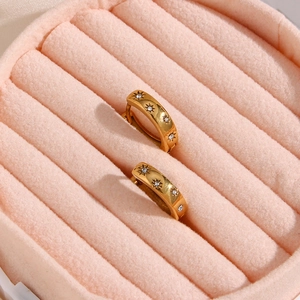 Detail of 18K gold-plated chunky hoop earrings with sunburst zircon stones in a pink box