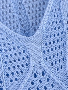 Détail macro de robe en tricot bleu clair avec texture en maille ajourée et col V
