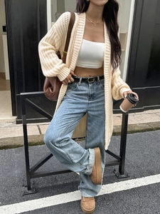 Elegante cardigan beige in maglia con jeans blu a gamba dritta per un look autunnale chic