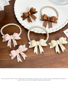 Detail of cellulose acetate bow hair clips and ties in marble pink and cream white