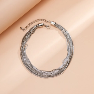 Detail of layered silver punk chain necklace with round beads and extension clasp