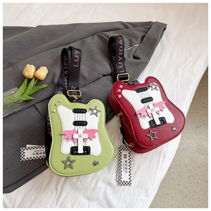 Detail of guitar-shaped punk crossbody bags with star studs and demon wing patches