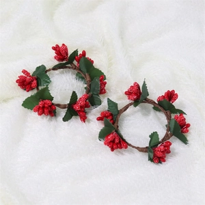 Detail of festive napkin rings with red berries and green pine needles on white fur