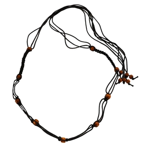 Bohemian body chain with brown wood beads and black woven rope on white background