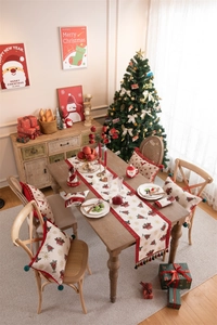 Close-up of jacquard Christmas table runner with festive deer, trees and tassels