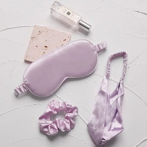 Lavender faux silk sleep set including eye mask, scrunchie and headband on elegant background