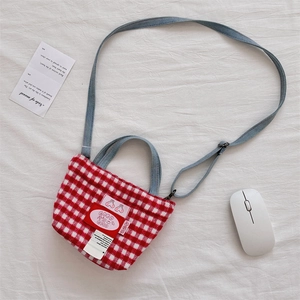 Detail of red and white plaid plush tote bag with cherry patch and denim shoulder strap