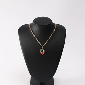 Detail of Christmas wreath pendant necklace with red bow on a black mannequin