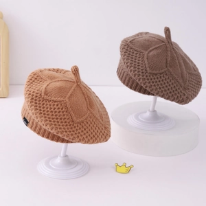 Detail of leaf-patterned knit pumpkin hat for girls featuring thick yarn and stem top