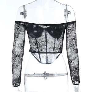 Macro shot of delicate floral lace pattern and mesh texture on black corset-style top
