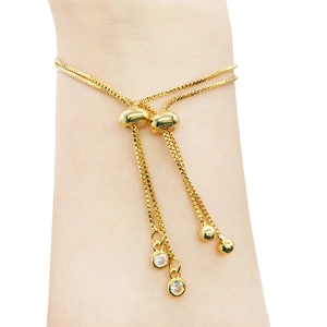 Close-up of adjustable gold slider bracelet with sparkling crystal charms on wrist