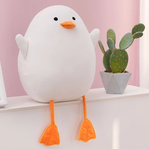 Detailed view of plush white duck toy sitting on a window sill with pink background