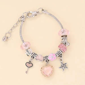 Close-up of heart charms and pink crystals on a silver snake chain bracelet