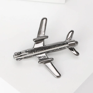 Minimalist dark grey metal airplane brooch pin shown from back view on white background