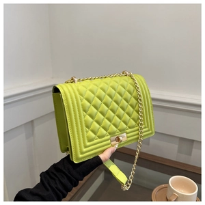 Detail of lime green quilted crossbody bag with gold chain and rectangular metal lock