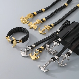 Detailed close-up of Viking Mjölnir and nautical anchor pendants in gold and silver finish