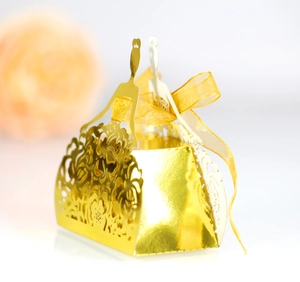 Detailed view of golden laser-cut gift box featuring floral patterns and a satin ribbon bow