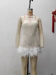 Detail of white sequin party dress featuring silver vertical stripes and feather hemline