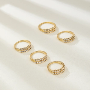 Detail of five-piece gold ring set with double-row sparkling diamonds and hollow engraving