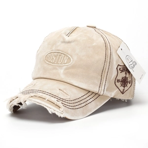 Detailed macro view of distressed khaki denim cap with vintage Boston embroidery
