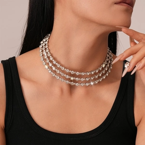 Close-up of triple-layered silver tennis necklace with sparkling diamond crystals on neck