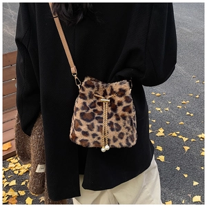 Detail of leopard print plush bucket bag with gold chain and dual pearl charms