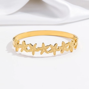 Detailed view of golden starfish cuff bracelet featuring intricate textured sea star motifs