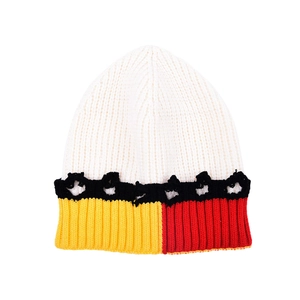 Détail de bonnet en maille color-block avec bande étoilée et bordure côtelée bicolore