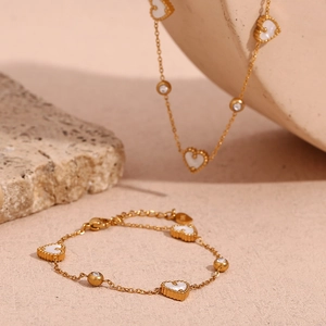 Detailed close-up of 18K gold-plated bracelet with shell heart and round diamonds on stone