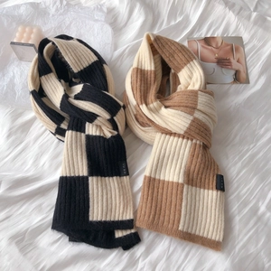 Close-up of thick checkered knit scarves in black-white and brown-white tones