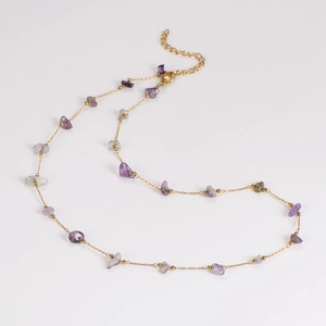 Detailed close-up of gold chain necklace with purple and grey crystal beads and clasp