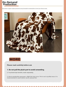 Detailed cow print flannel blanket texture on a cozy brown leather sofa armchair