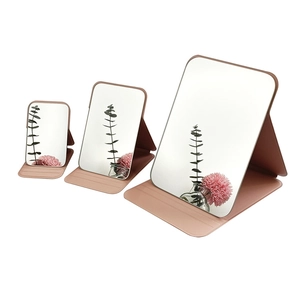 Three sizes of pink PU leather folding makeup mirrors on white background