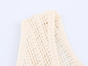 Detailed close-up of cream hollow crochet knit fabric with intricate floral lace texture
