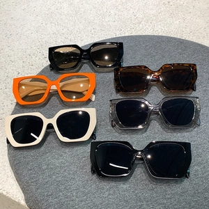 Flat lay of multiple retro square frame sunglasses in assorted colors on a felt mat