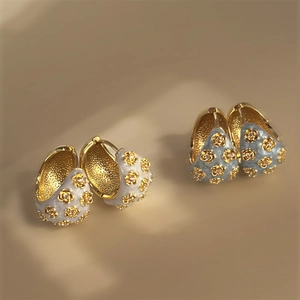 Detail of vintage flower enamel hoop earrings with gold floral accents and crystals