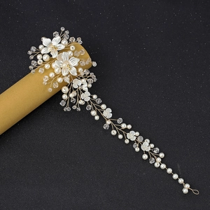 Detail of bridal hairband with white flowers, crystals and pearls on gold wire
