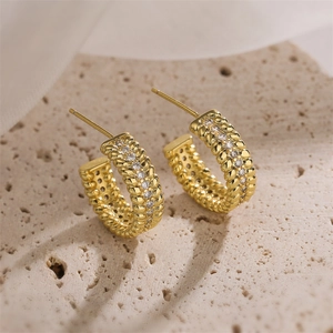 Detailed macro view of 18K gold-plated C-shaped earrings with fine zircon pavé settings