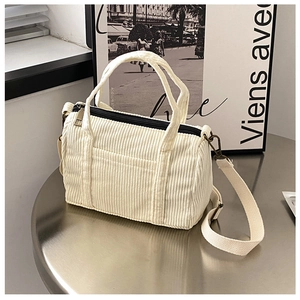 Detail of off-white corduroy Boston bag with black zipper and vintage bronze hardware